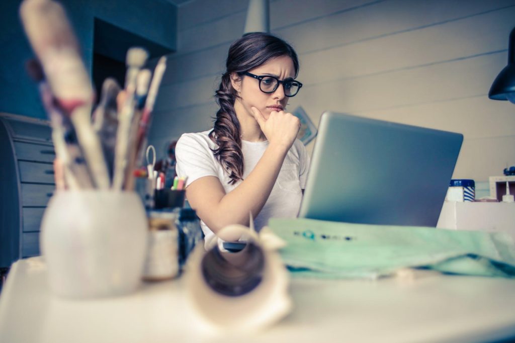 woman looking at laptop-laptop-thinking-choosing