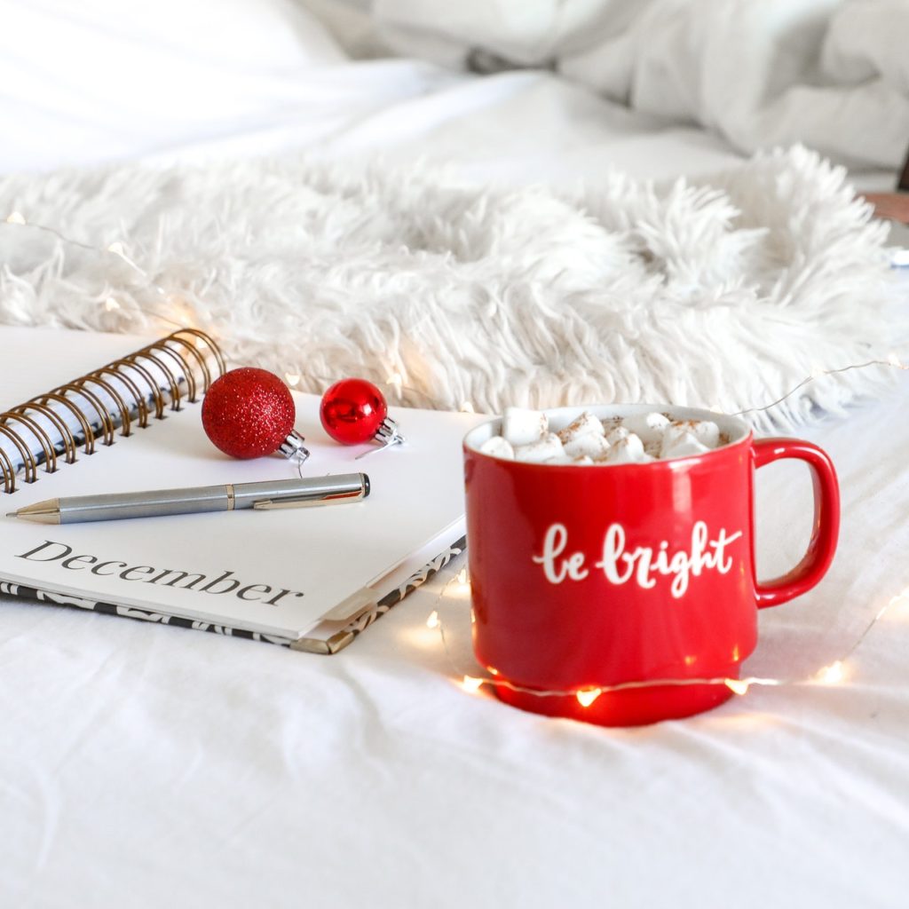 red-ceramic-mug-on-white-mat-beside-notebook-1661961