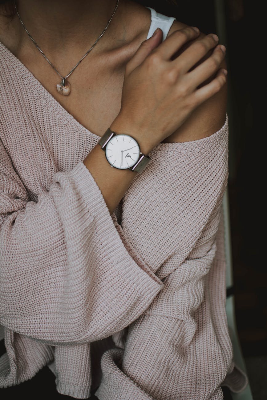 woman wearing beige crochet sweater and round white analog watch closeup photo