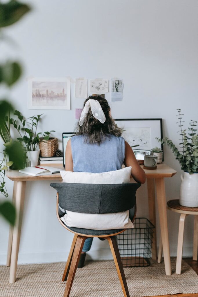 unrecognizable woman at table with laptop