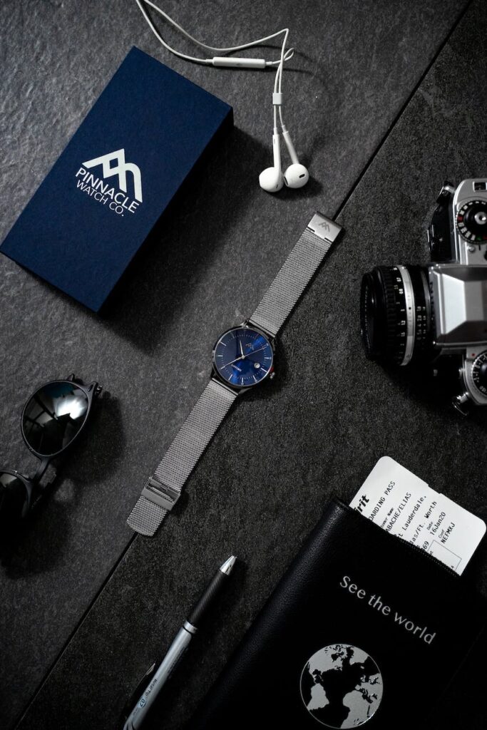 sapphire analog watch beside analog camera