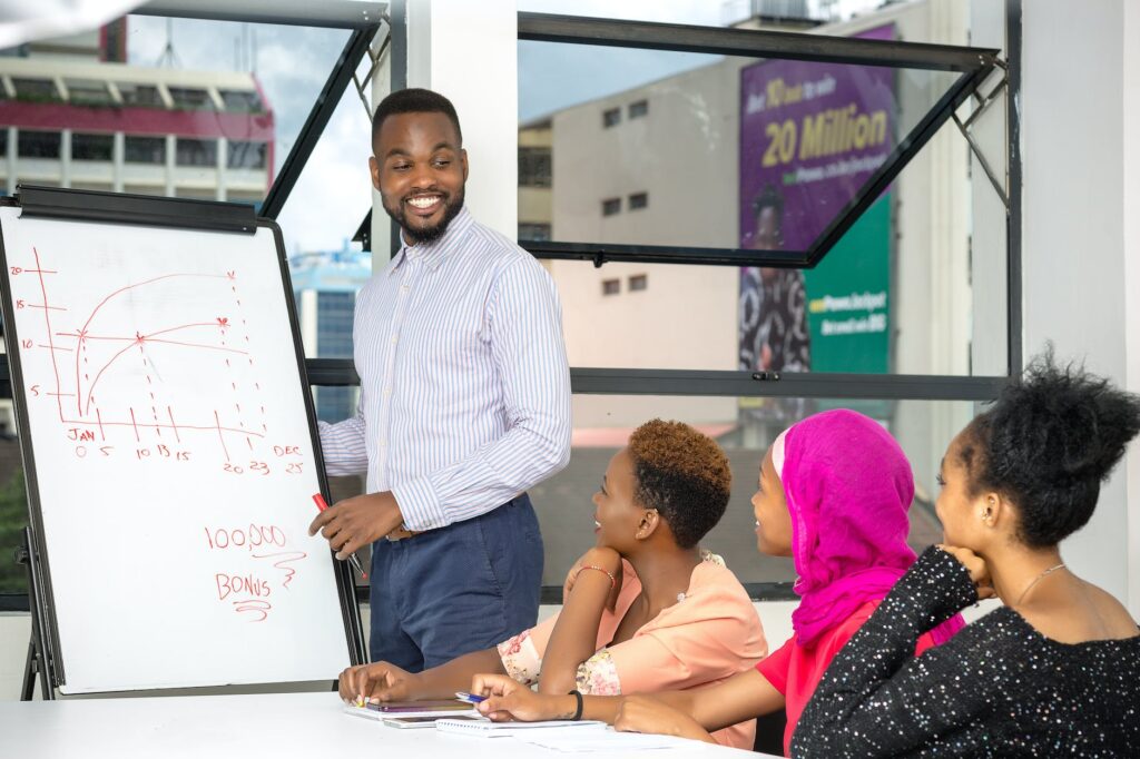 smiling man presenting project on whiteboard in office