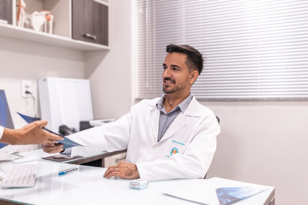 person handing documents to doctor