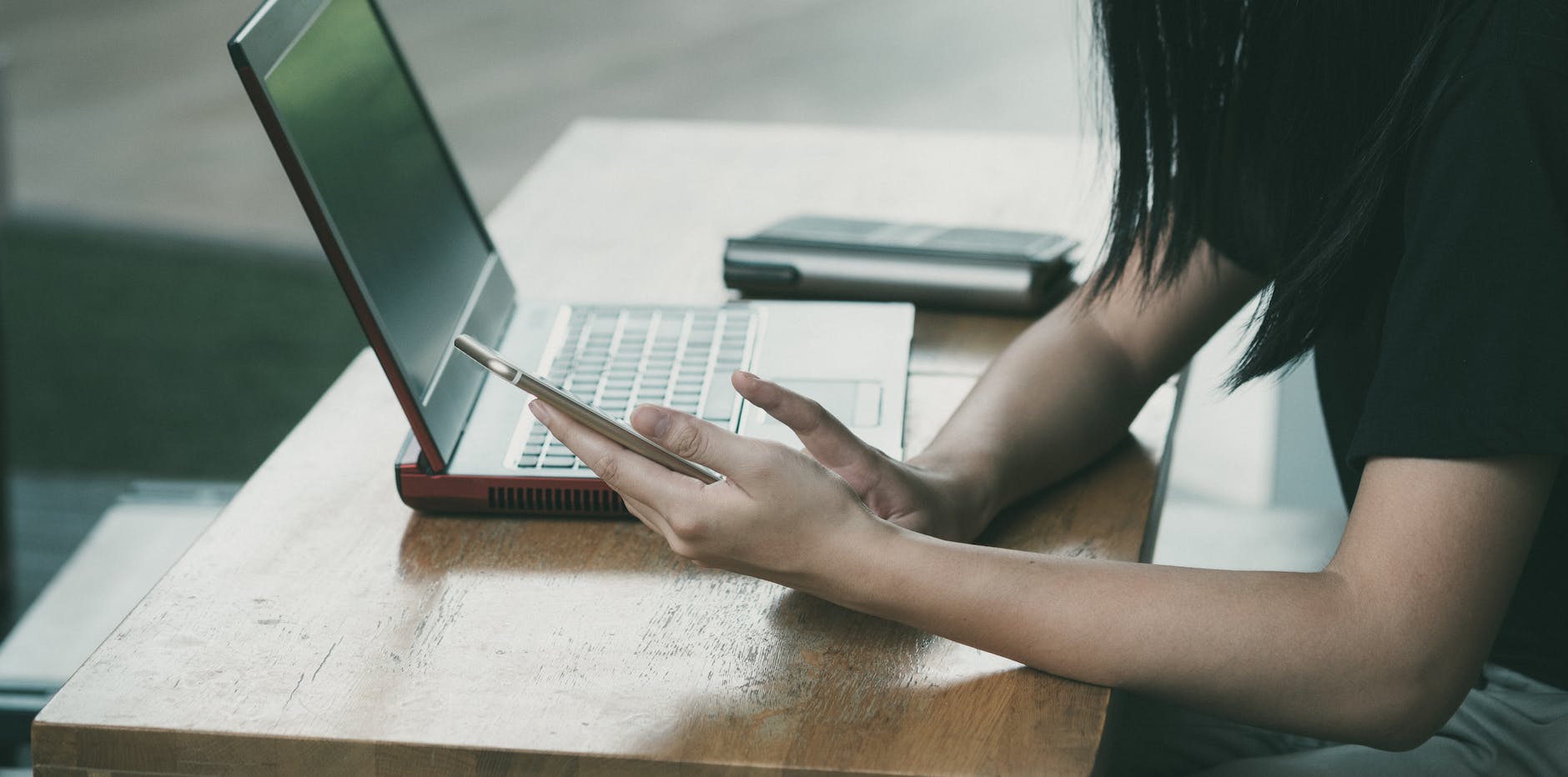 woman sitting on chair beside table while using phone