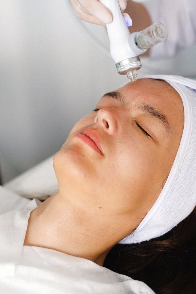 specialist making face skin procedure with modern equipment