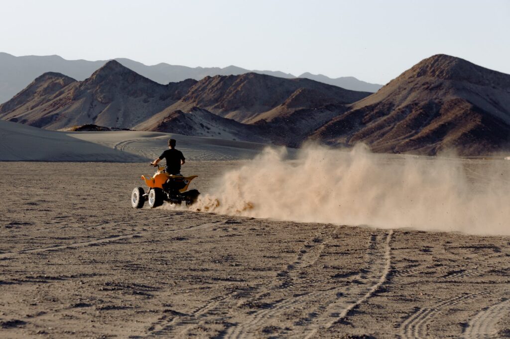 man riding atv in desert viewing mountain