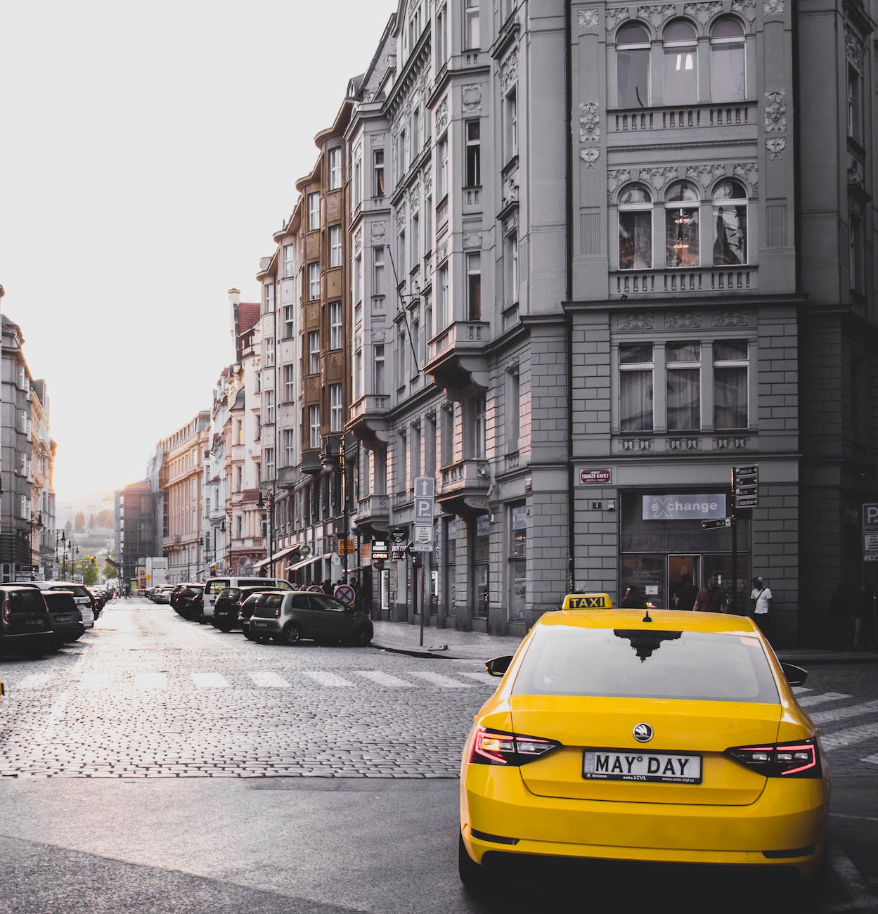 yellow taxi vehicle near gray concrete building