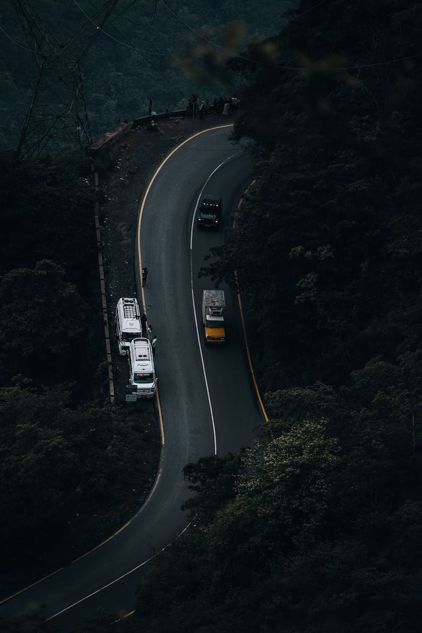 aerial footage of trucks on a curved road in a dark landscape