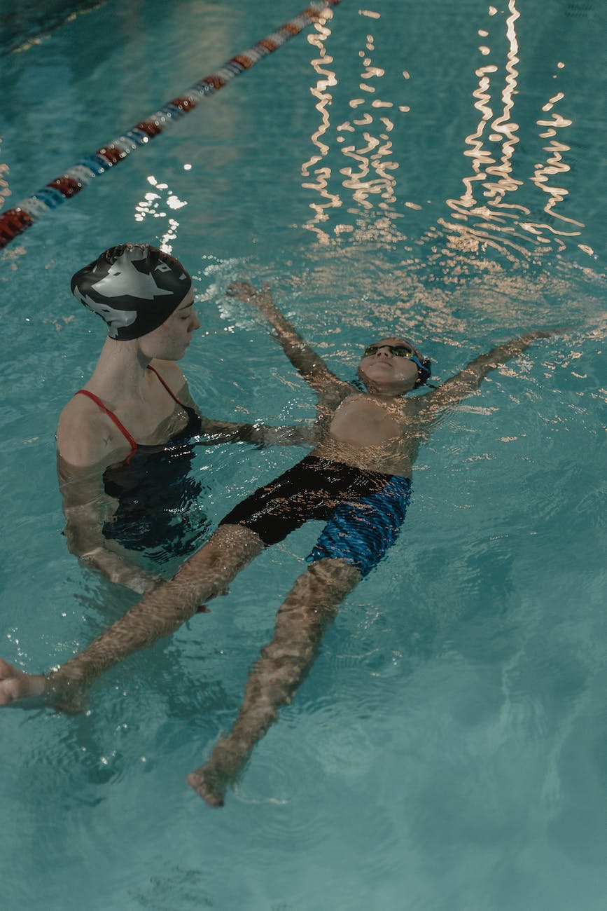 woman teaching a child on how to swim