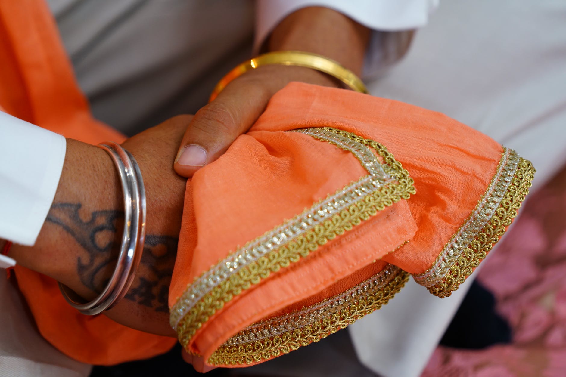 crop faceless indian groom in traditional clothes and bracelets