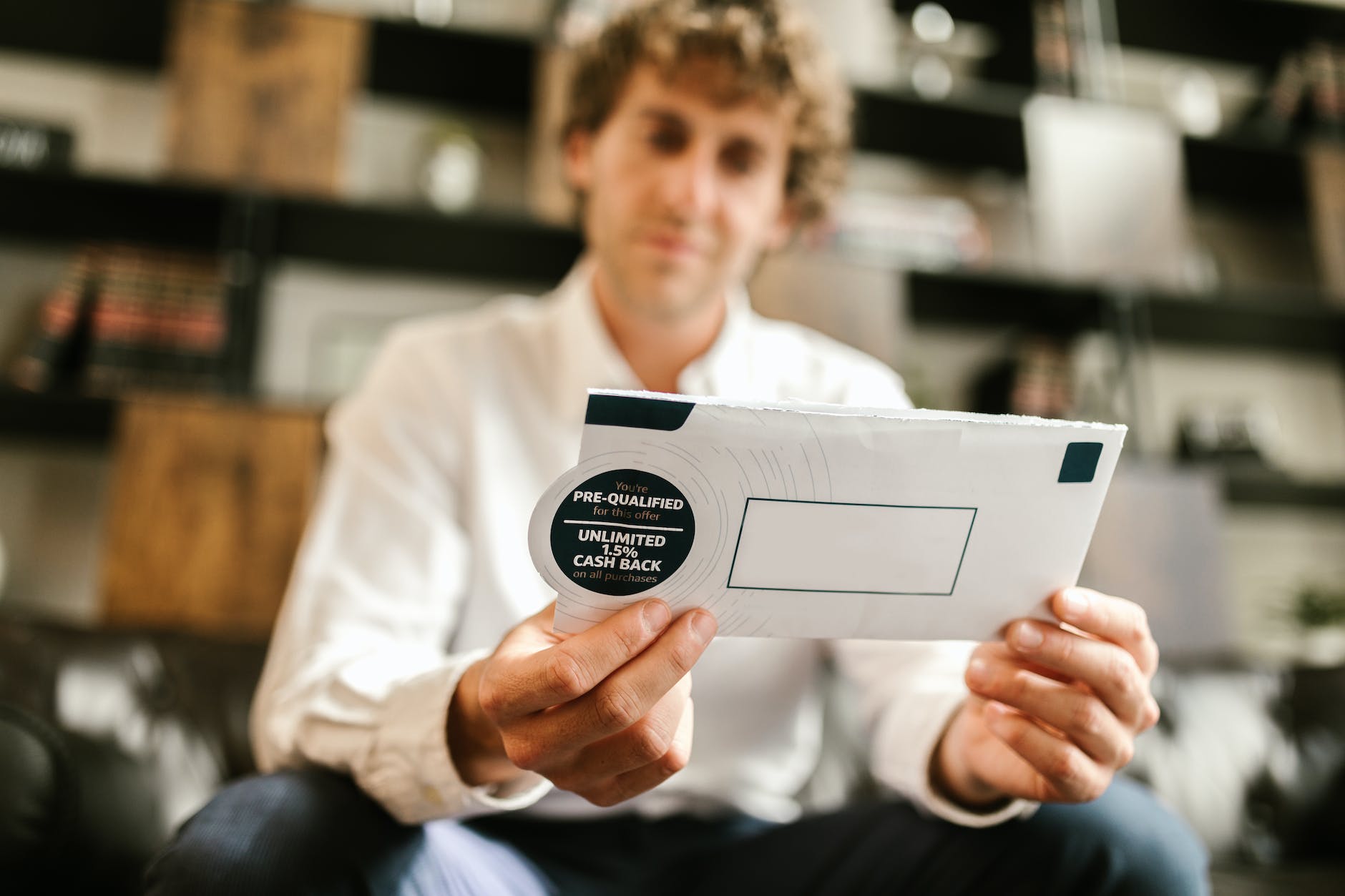 man in white dress shirt holding white envelope