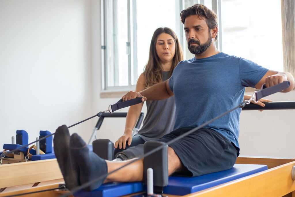 a man in blue shirt exercising with supervision