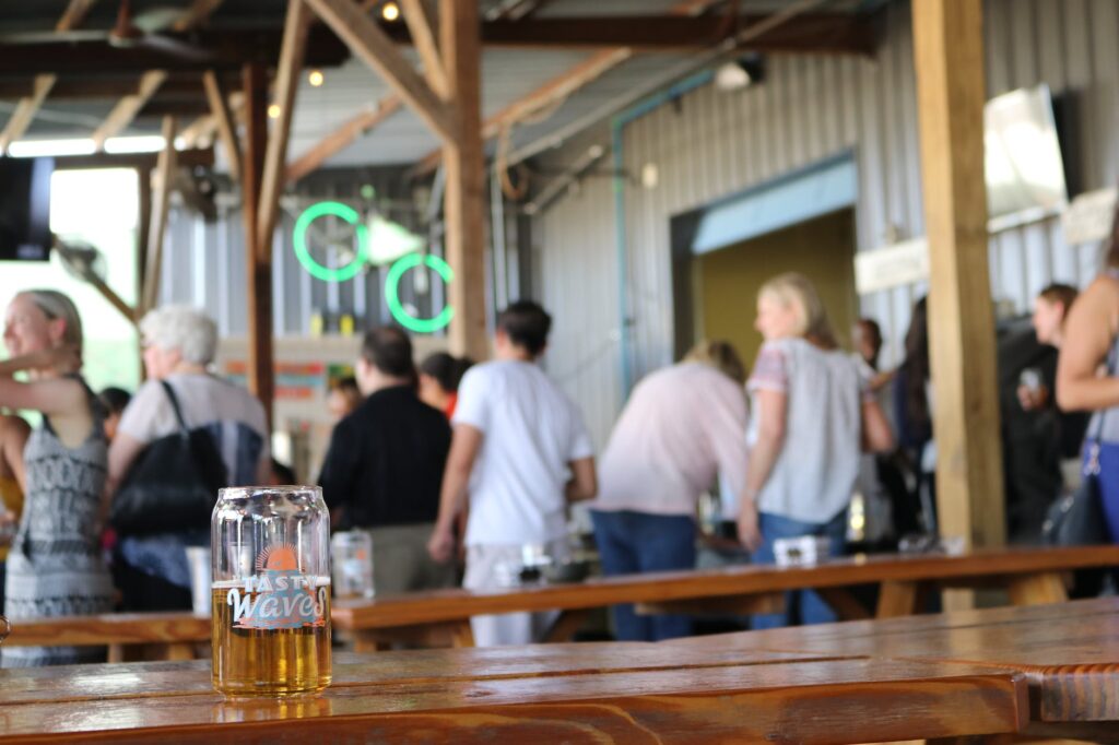 selective photography of clear beer glass on top of brown wooden table