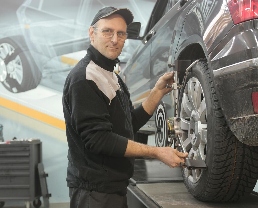 man in black jacket standing beside black car