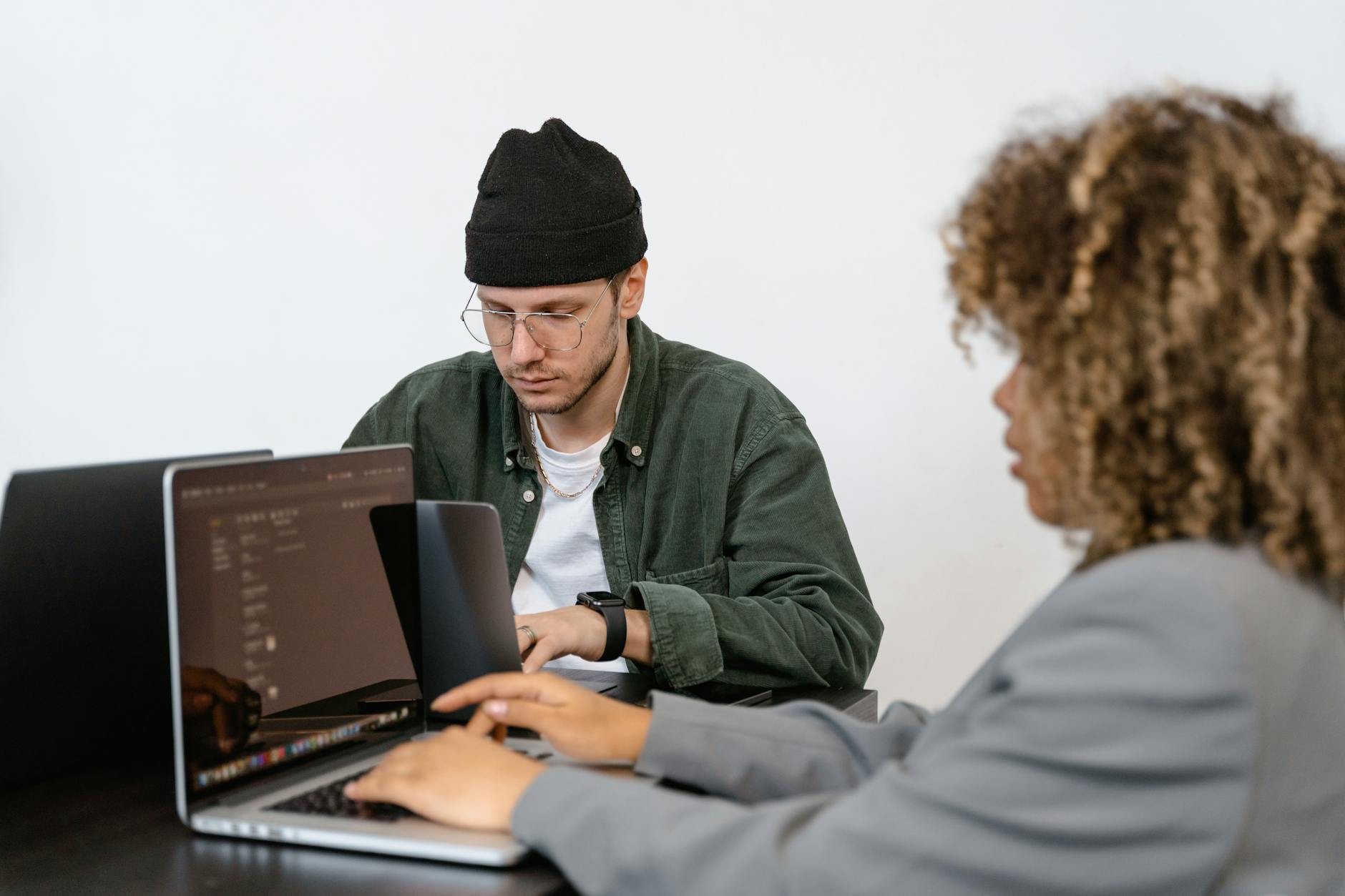 man in green jacket using black laptop computer