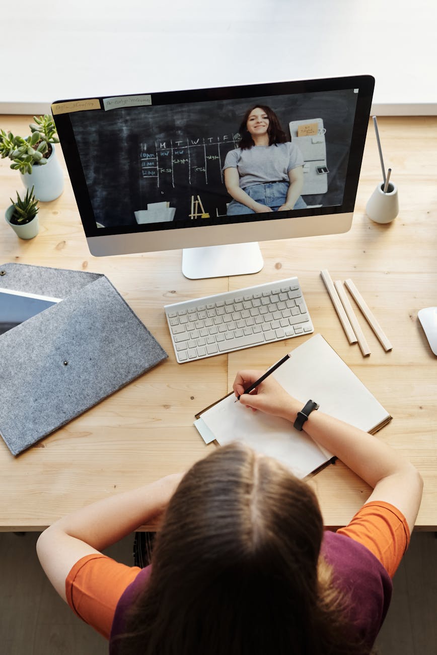 top view photo of girl watching video through imac