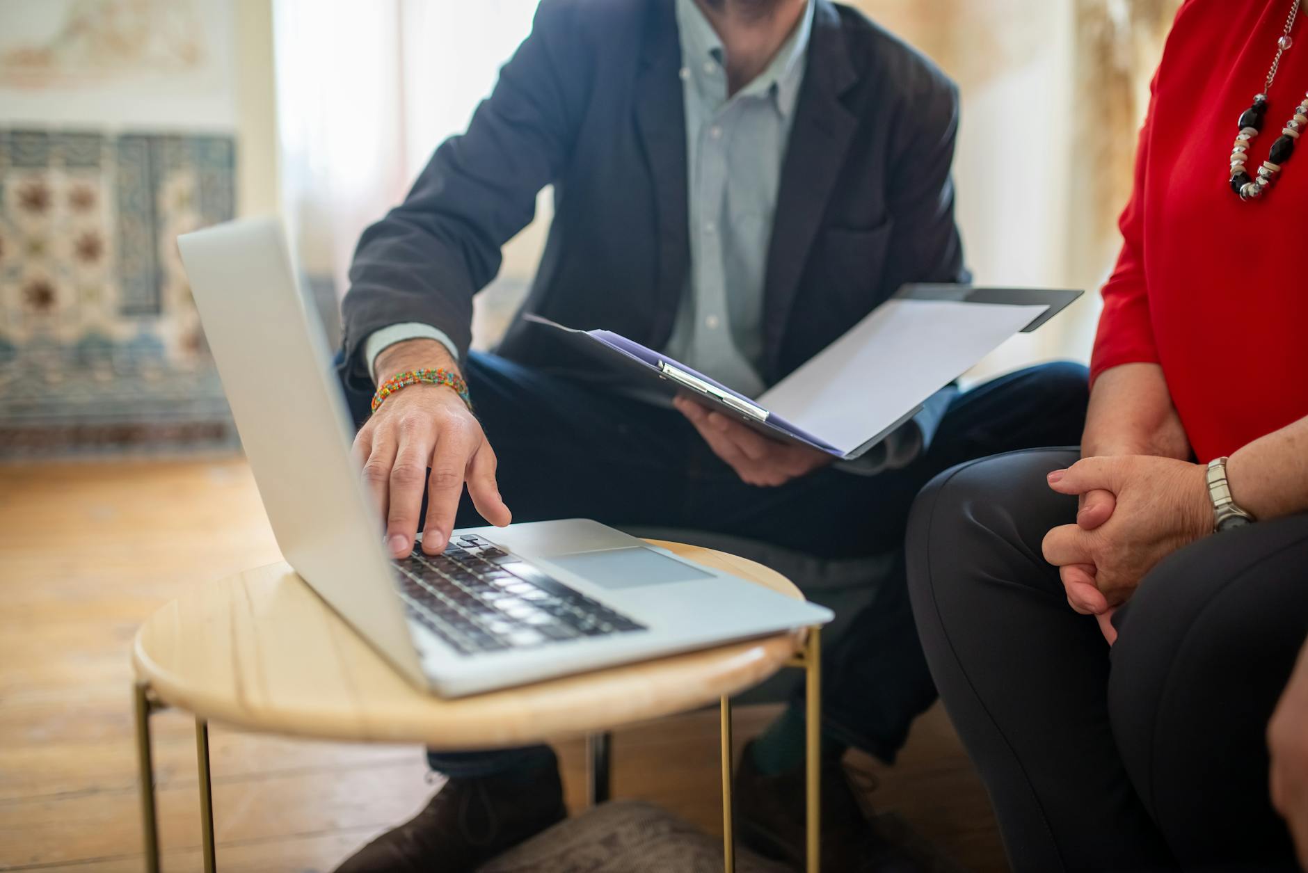 lawyer showing documents to a woman and using a laptop