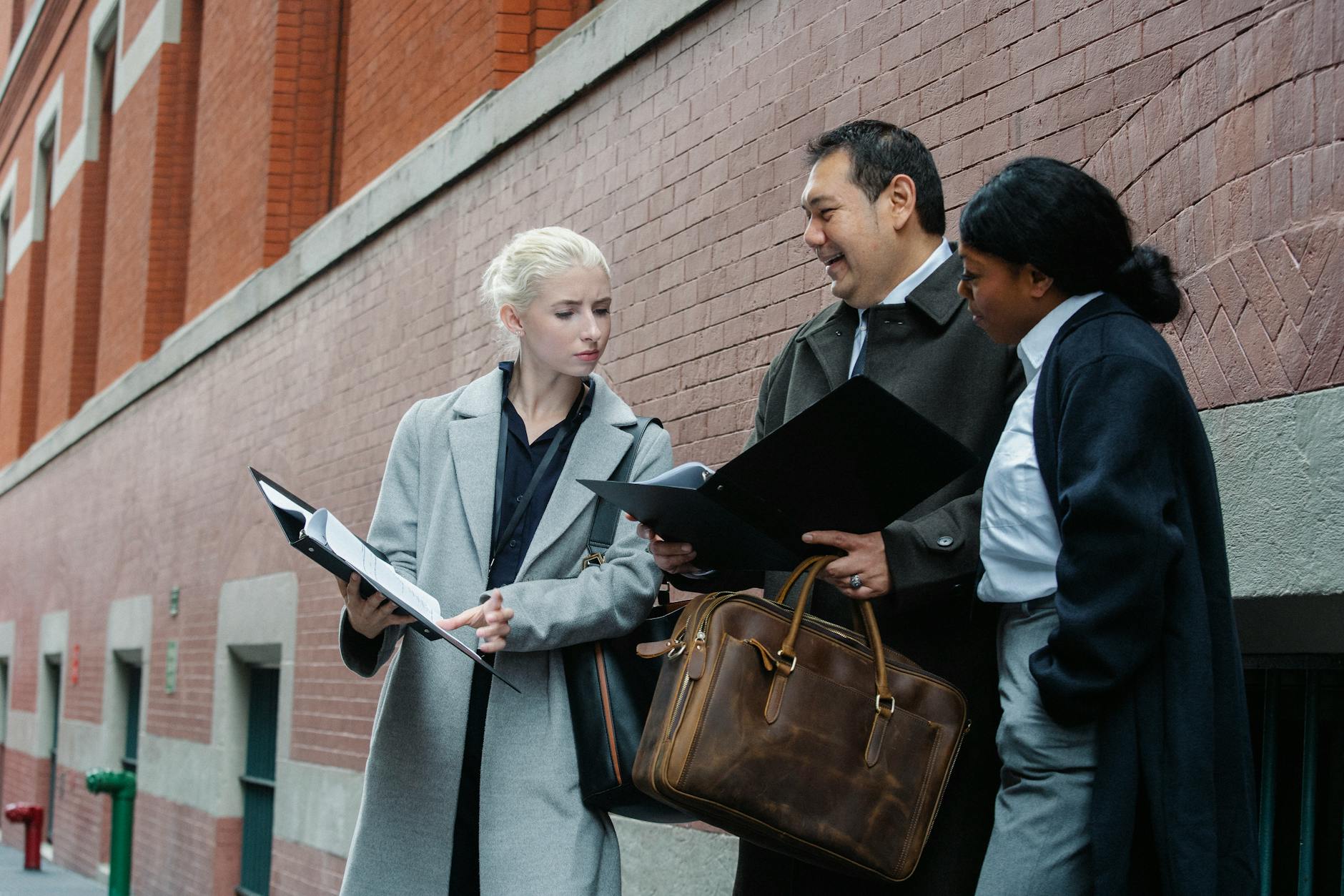 group of multiethnic colleagues reading contract details standing on street