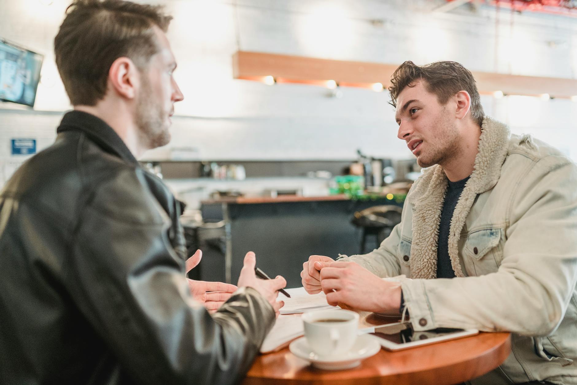 coworkers discussing project at table with coffee