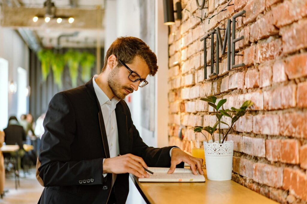 man in black suit jacket using laptop computer