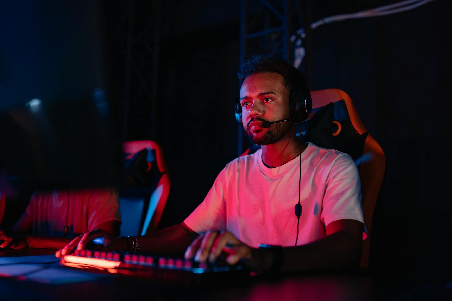 photograph of a man in a white shirt playing on a computer