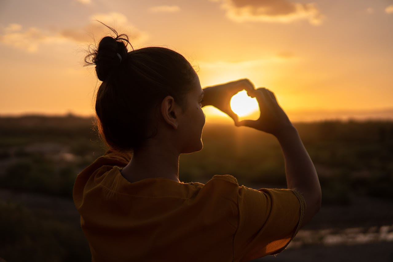 woman using love hand sign-sunset