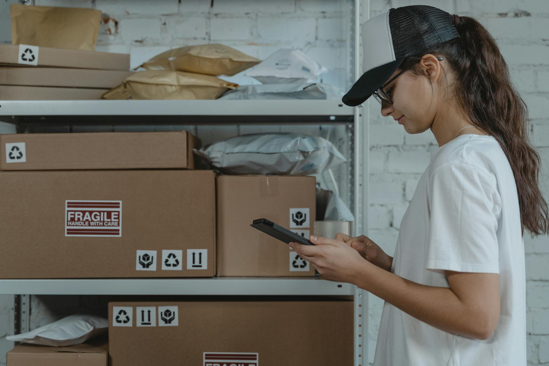 woman in white shirt holding black smartphone