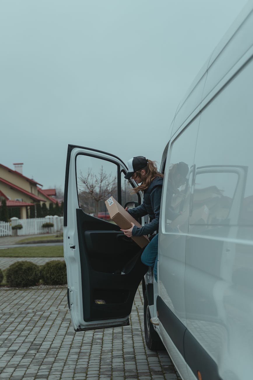 man in black jacket sitting on blue car