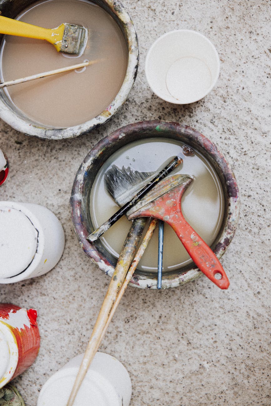 paintbrushes in cans with water