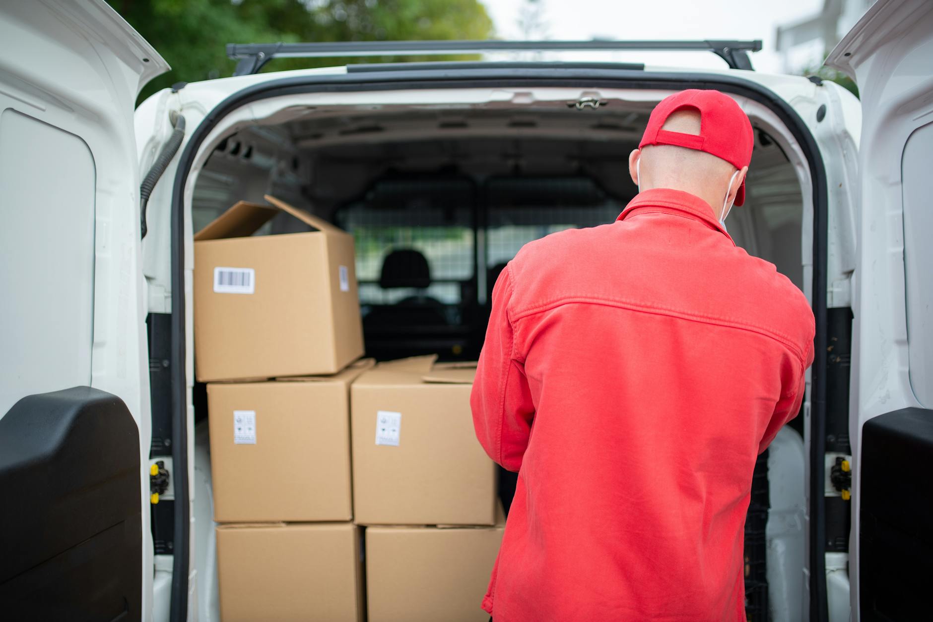 a man arranging cardboard boxes in the van