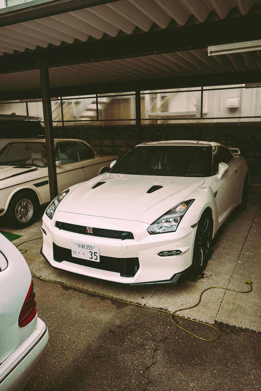 a white car parked under a garage with a white car parked next to it