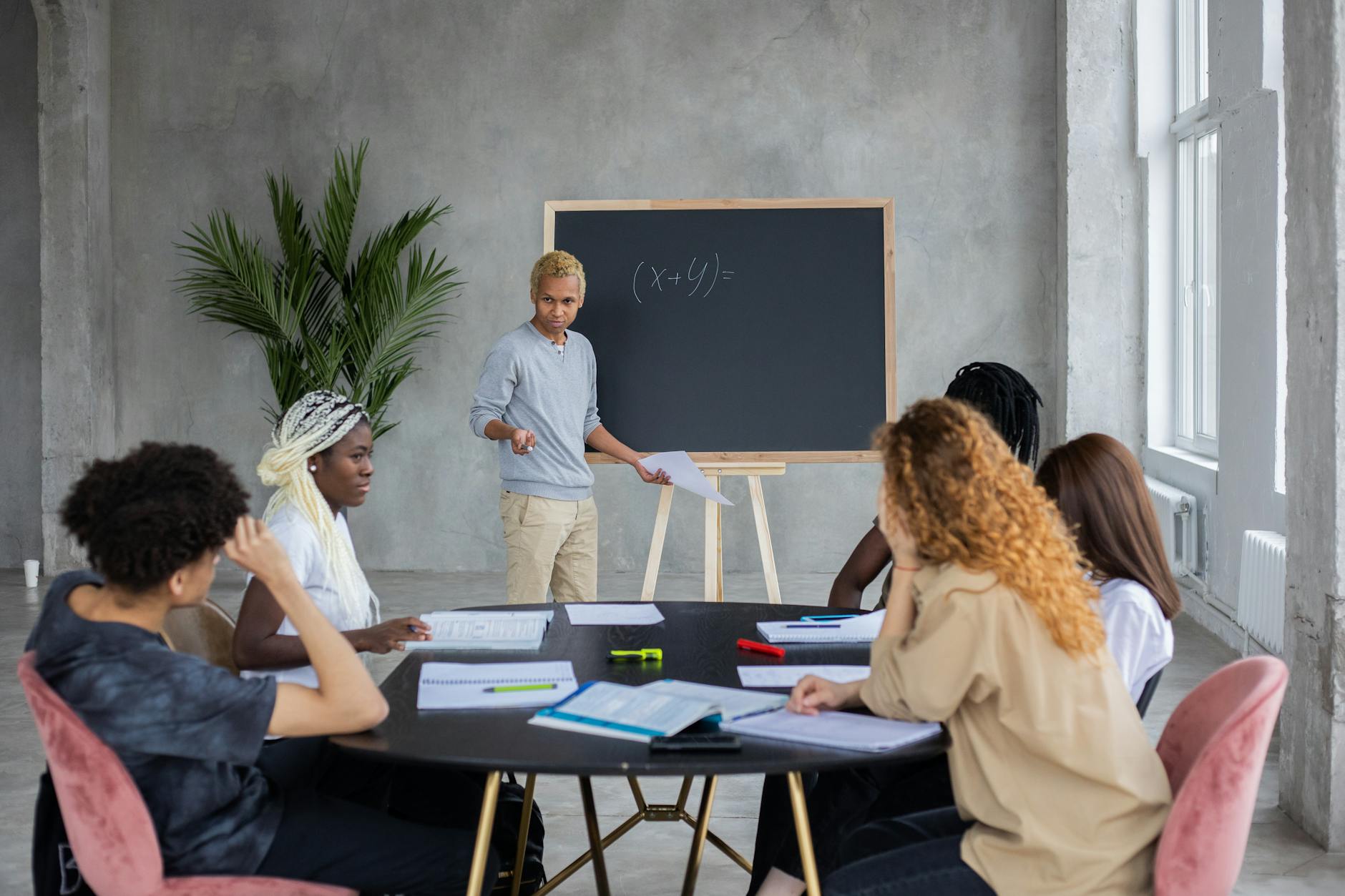 multiethnic students studying math together at round table