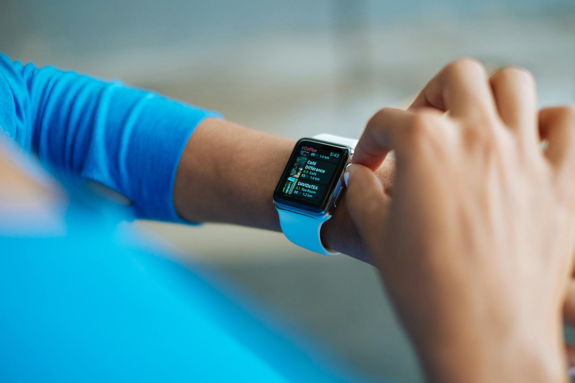 person in blue long sleeve shirt using smart watch