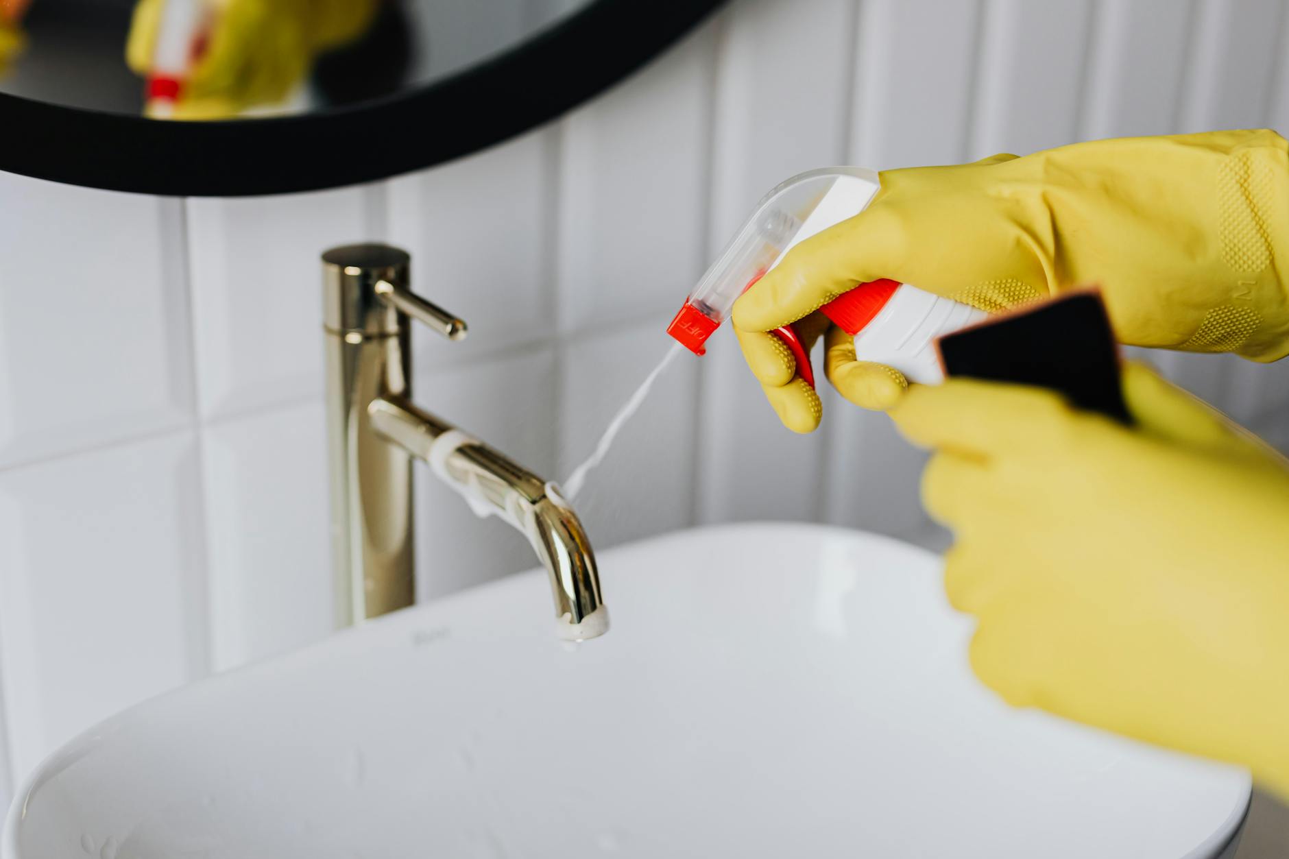 faceless cleaner in gloves tiding up bathroom