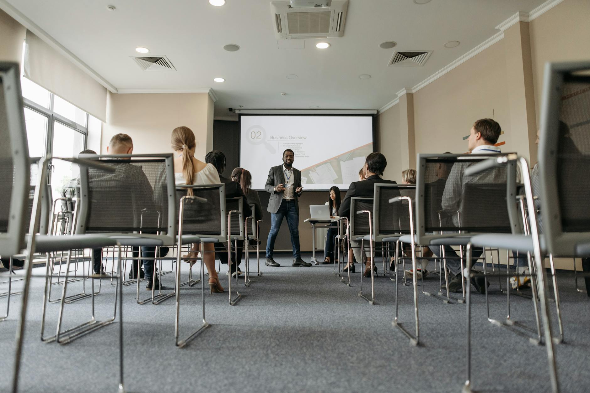 a man standing near a projector screen