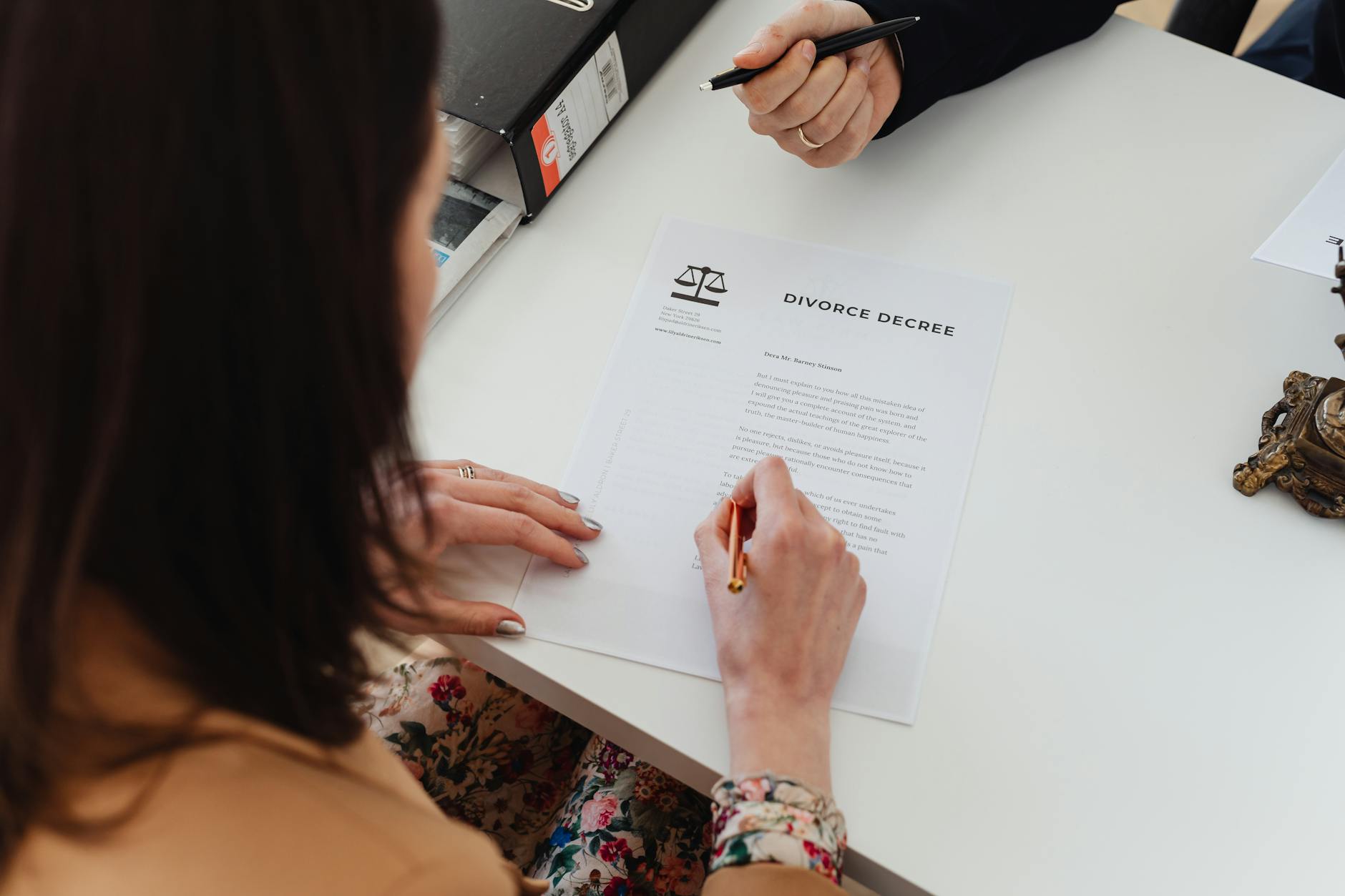 woman holding a pen signing on a paper