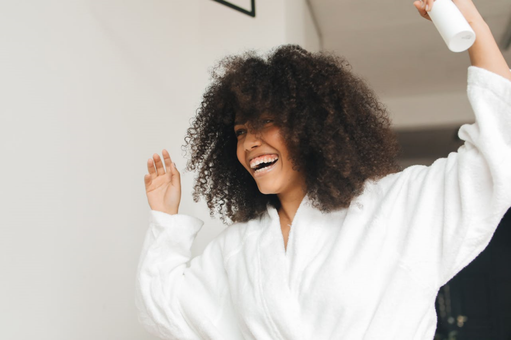 womand in white bathrobe holding hairspray