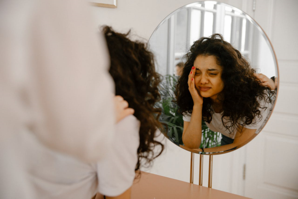 woman-in-white-long-sleeve-shirt looking in mirror