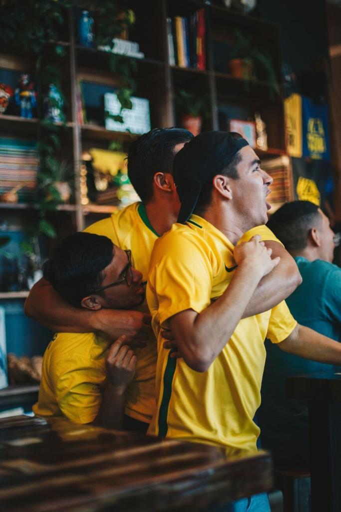 three men wearing yellow shirt embracing each other