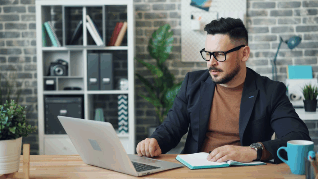 Happy Man Sitting at Table in Office