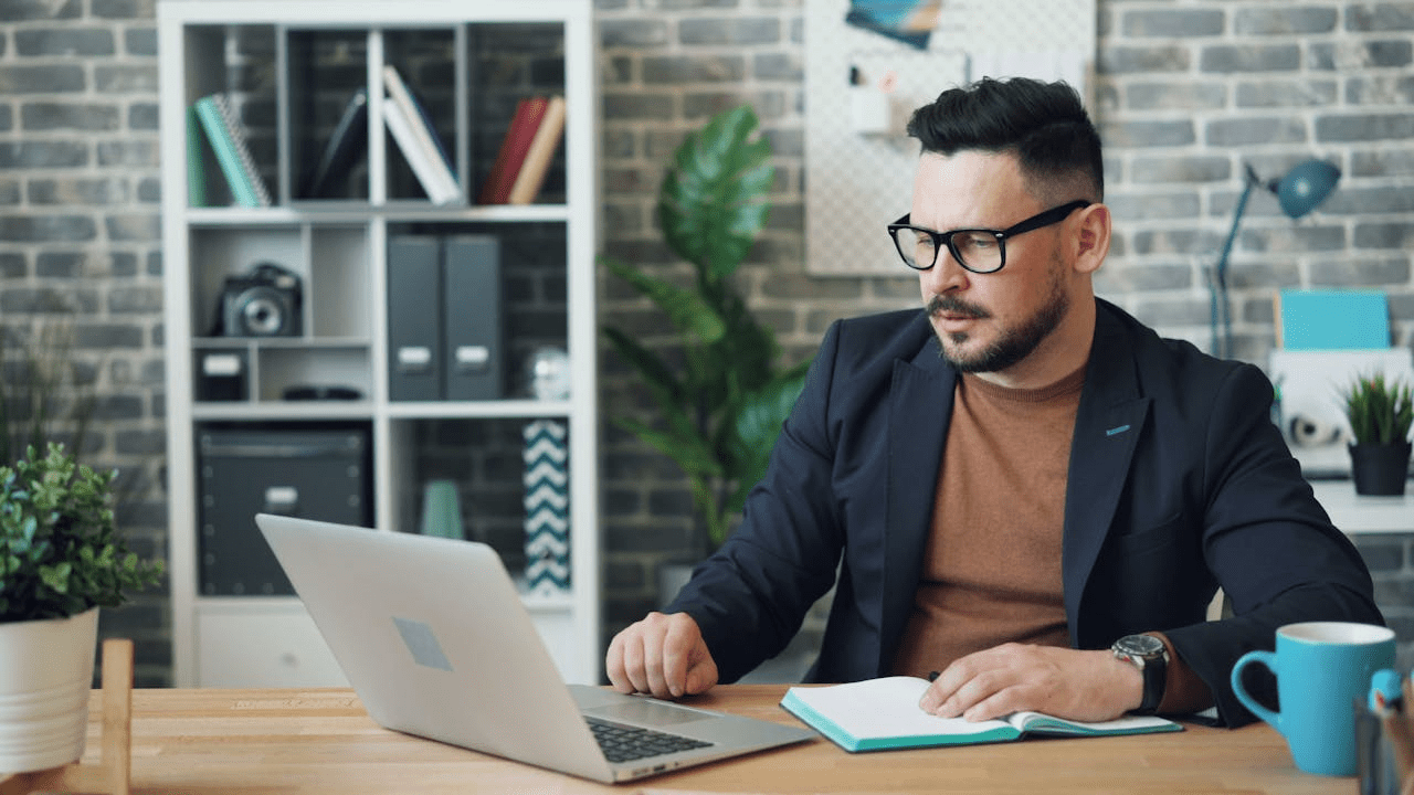 Happy Man Sitting at Table in Office