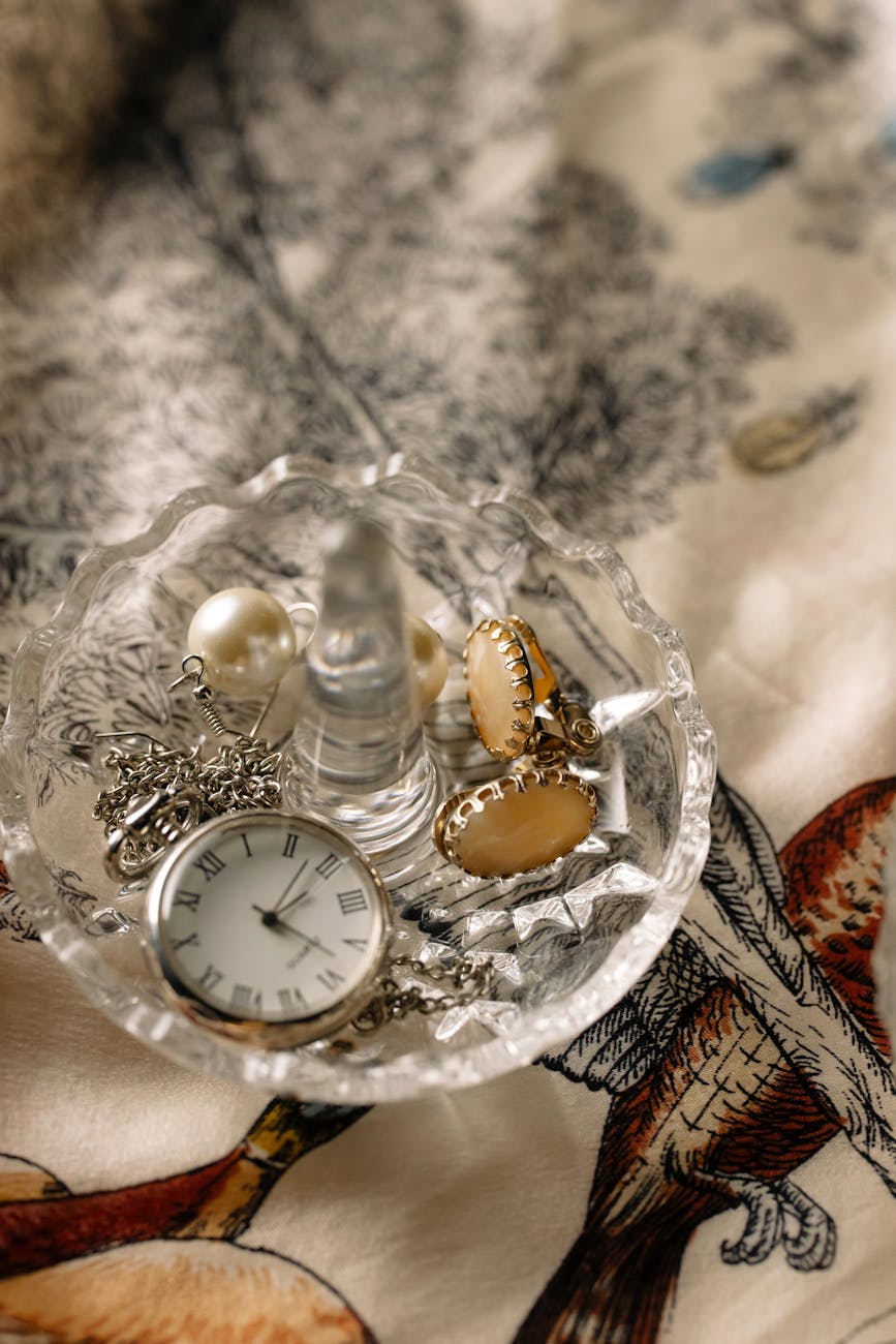 clock and accessories in a clear bowl