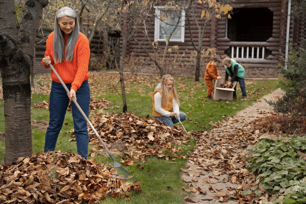 women cleaning leaves in autumn
