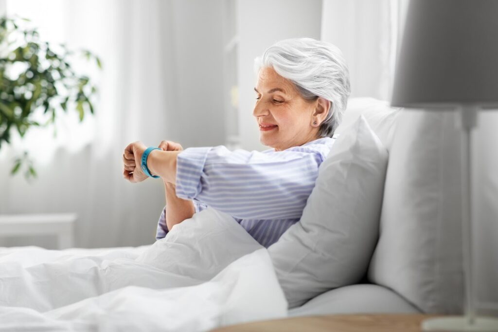 woman in bed taking pulse
