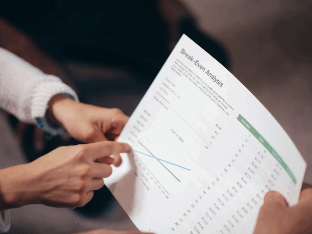 A Person Holding White Printer Paper - Lead Grow Develop - Business, Technology, Personal Development A Person Holding White Printer Paper with financials break even analysis