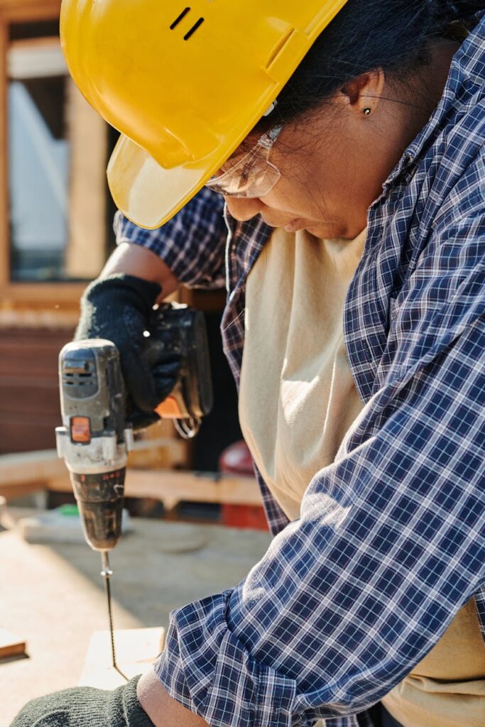 a woman drilling a screw on wood