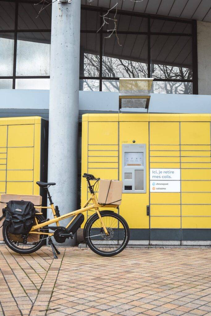 yellow cargo bike by parcel locker in france