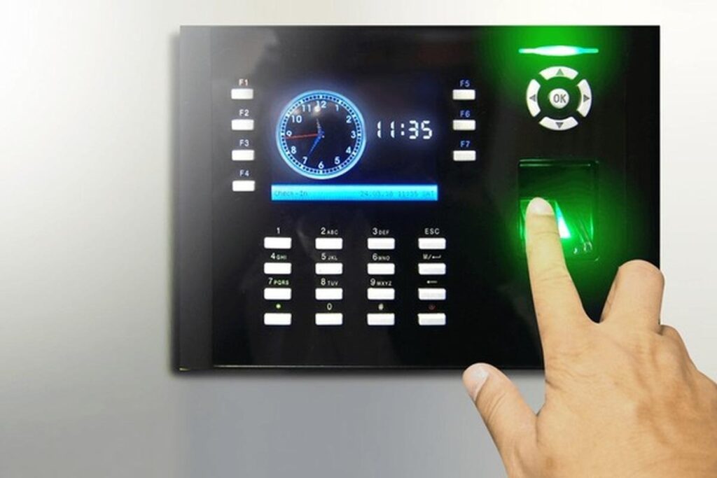 Access control keypad with numeric pad and a glowing green fingerprint reader being pressed by a hand