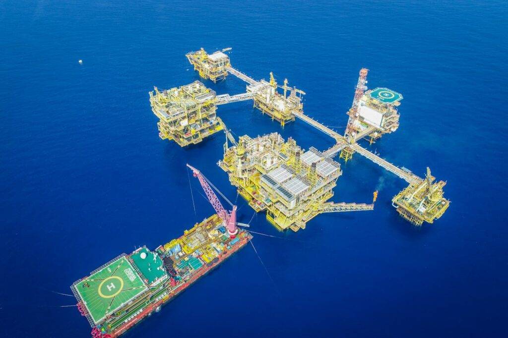Aerial shot of an offshore oil platform complex in the ocean, showcasing industrial infrastructure