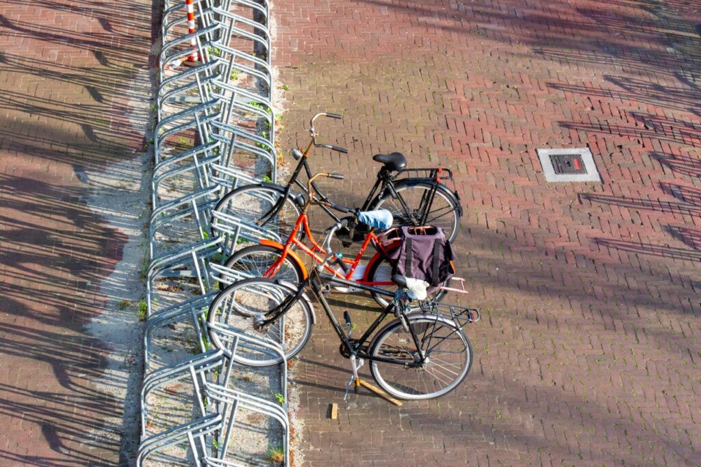 Overhead view of bicycles parked in a city bike stand with shadows on the pavement